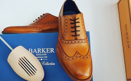 Ein braune Paar Lederschuhe auf einer blauen Schuhbox von Barker
